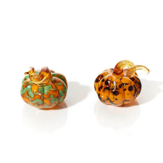 Halloween glass pumpkin ornaments with assorted swirl patterns, perfect for adding elegance to festive décor displays.